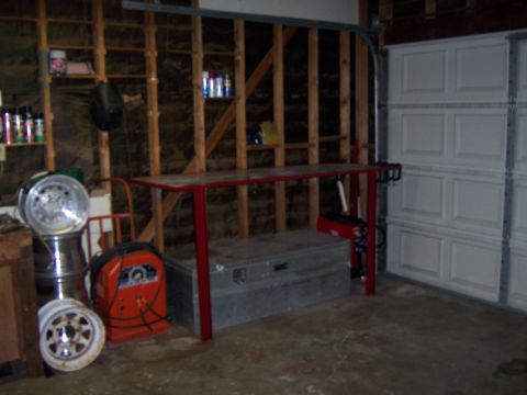 1991 Ford Bronco - Photograph of a custom red steel workbench in a garage next to welding equipment and wheels.