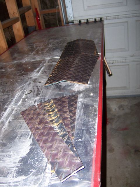 1991 Ford Bronco - Photograph of bent and cut diamond-plate metal sheet sitting on a fabrication workbench.