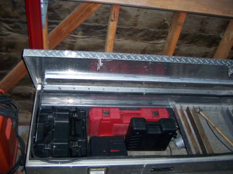 1991 Ford Bronco - Photograph of an open metal toolbox containing power-tool cases and stored items.