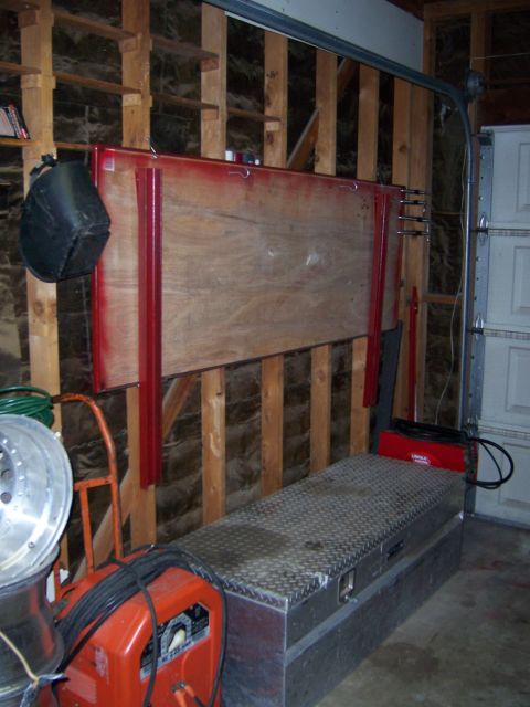 1991 Ford Bronco - Photograph of a custom red-framed plywood panel hanging in a garage above a metal toolbox.