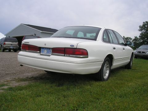 1996 Ford Crown Victoria - This 1996 Ford Crown Victoria is seen from the rear, parked on grass with a garage and another vehicle in the background.