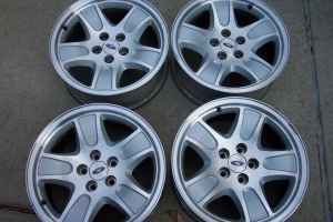 1996 Ford Crown Victoria - Four silver 5-spoke Ford wheels are displayed against a neutral background.
