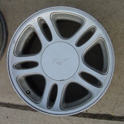 1996 Ford Crown Victoria - A silver wheel with a running horse emblem, likely from a Ford Mustang, is shown.