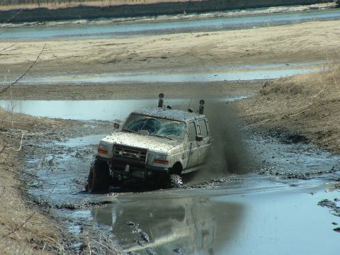 1992 Ford F-350 - This 1992 Ford F-350 is navigating a muddy terrain, kicking up a lot of spray.