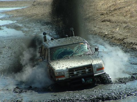 1992 Ford F-350 - This 1992 Ford F-350 is deep in mud, with water and dirt splashing around it.