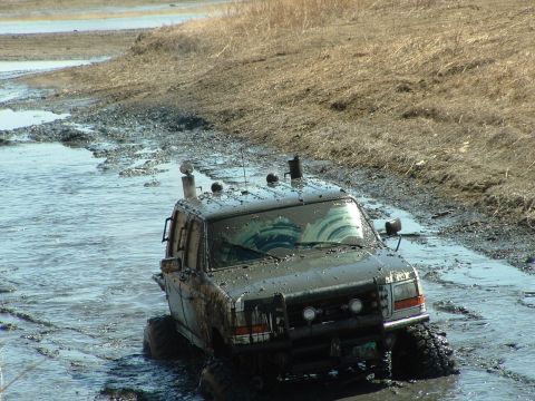1992 Ford F-350 - This 1992 Ford F-350 is stuck deep in muddy water, with its snorkel and off-road tires visible.