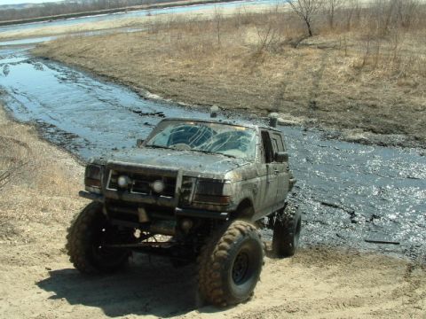 1992 Ford F-350 - This heavily modified 1992 Ford F-350 is shown off-roading through a muddy creek.