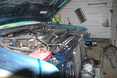 1996 Ford Bronco - The engine bay of a 1996 Ford Bronco is visible with the hood open, revealing the engine and front-mounted winch.