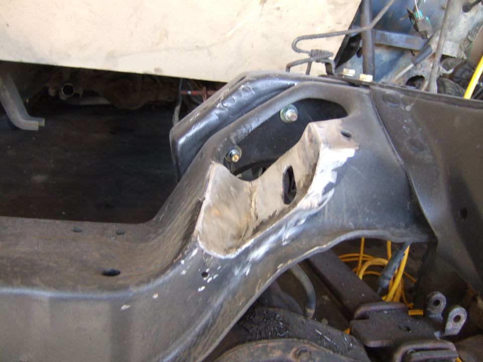 Close-up of a heavily modified vehicle frame with cut sections and visible bolts