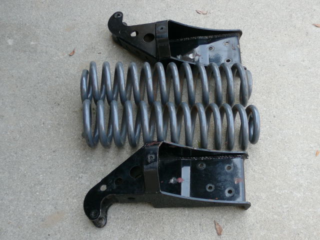 Pair of black coil-spring buckets with gray coil springs on concrete