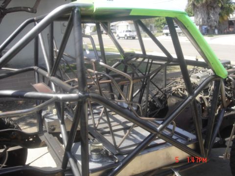 1995 Ford Bronco - The interior of a custom off-road vehicle shows a complex roll cage structure with green accents on the roof.