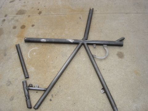 1995 Ford Bronco - Metal roll cage section with several tubes welded together, lying on concrete.