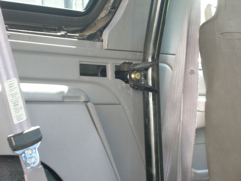 Black roll bar bolted to gray interior trim panel in a Ford Bronco