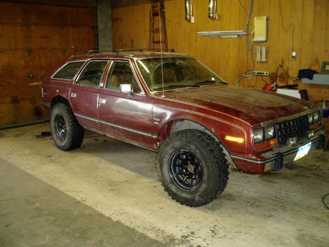 2000 Ford E350 - This AMC Eagle wagon has been modified with large off-road tires and sits in a garage.