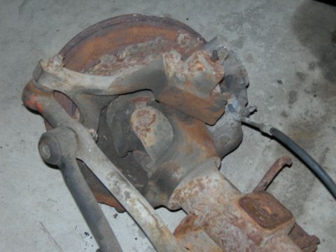 1985 Ford Bronco - Close-up of a heavily rusted vehicle suspension component, likely from an older truck or SUV.