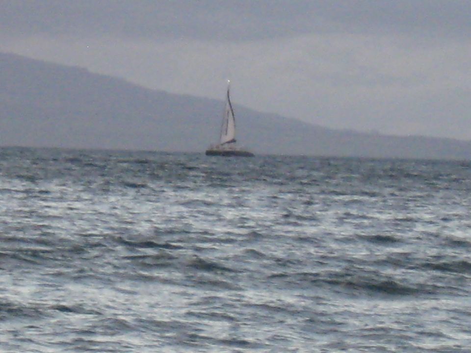 Sailboat on the water with mountains in the background.