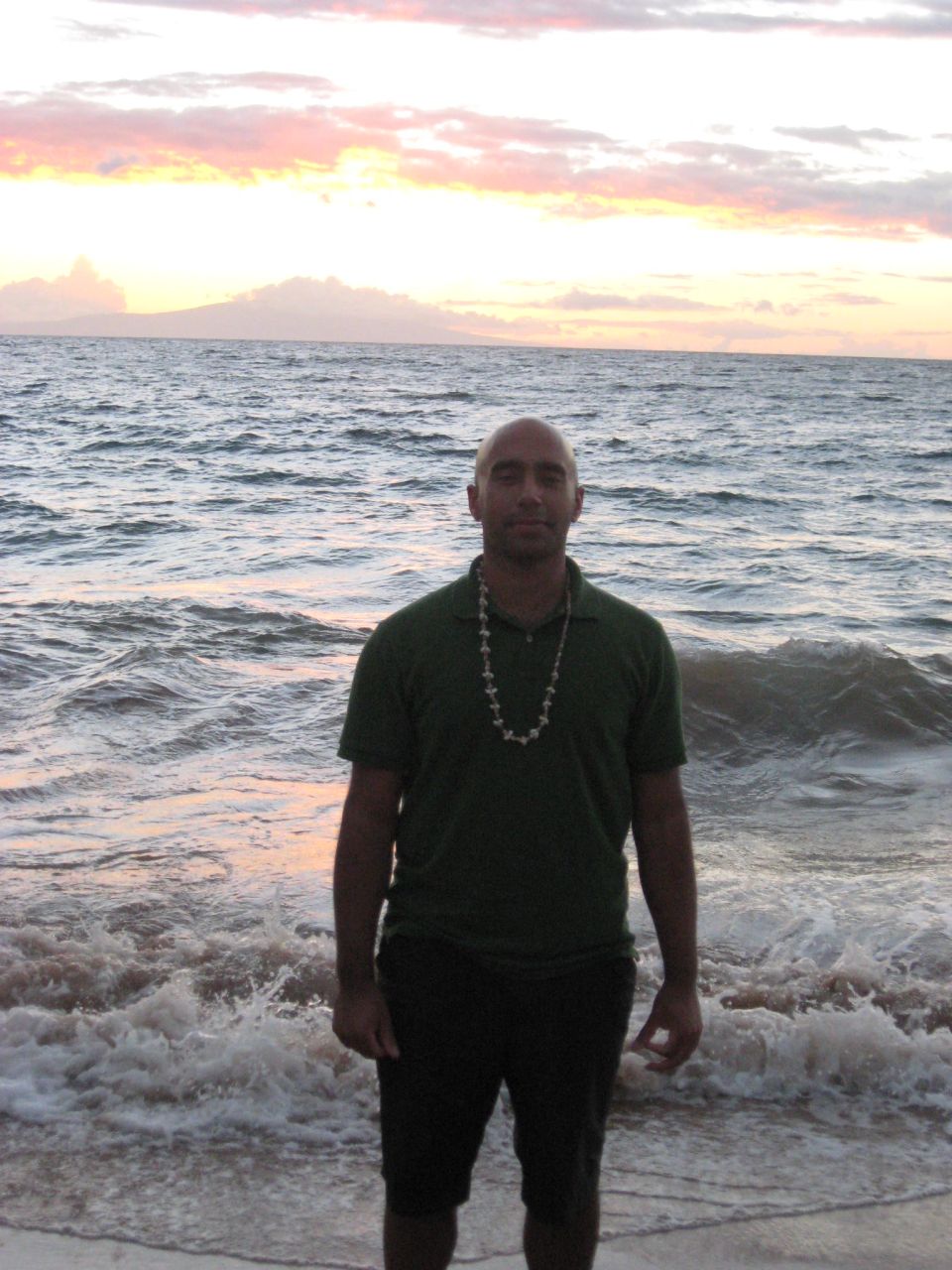 Man on beach at sunset with waves