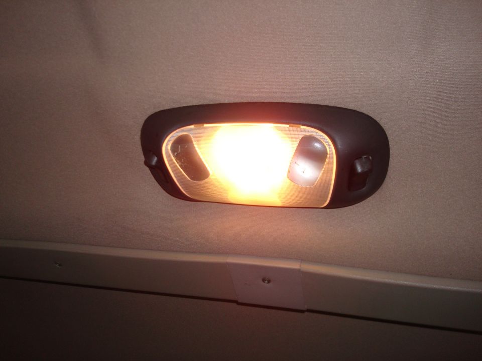 Illuminated overhead dome light in a vehicle headliner