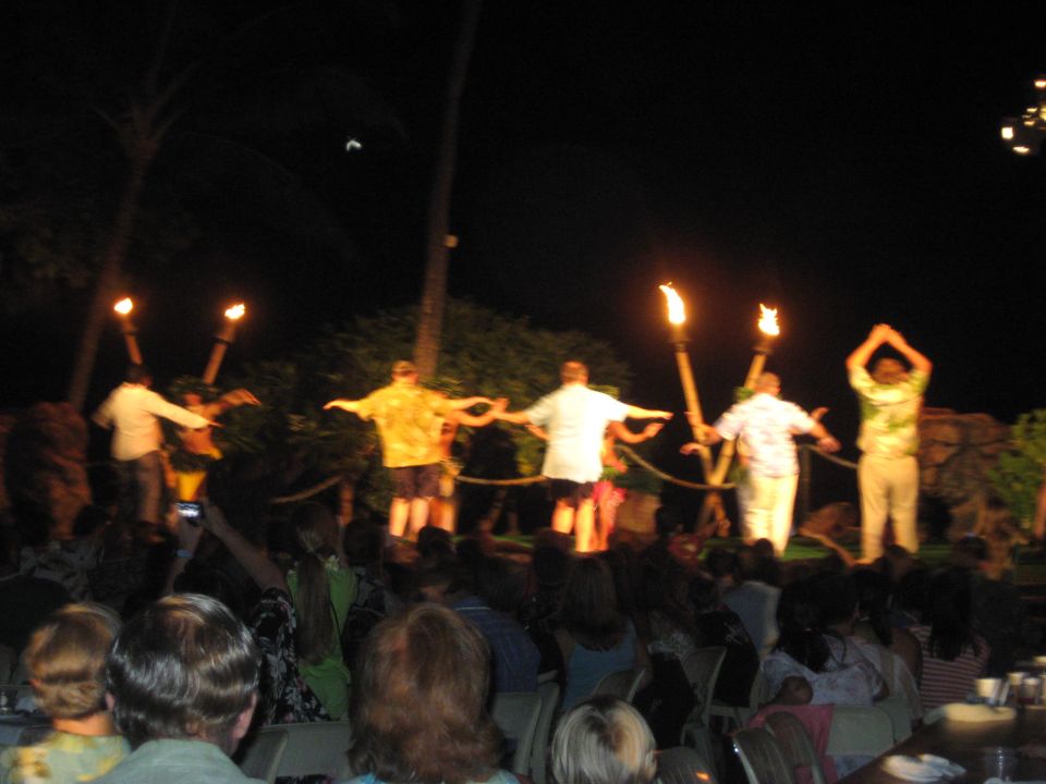 Fire dancers performing at night with torches lit.