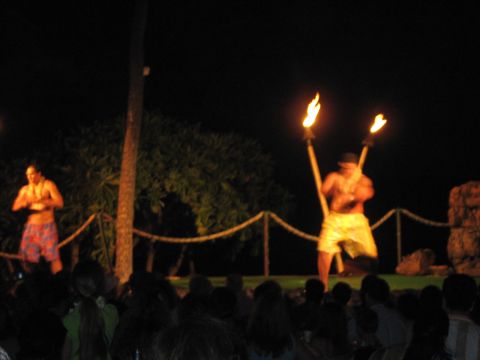 1991 Ford Bronco - A nighttime luau performance features two men with flaming torches entertaining an audience.