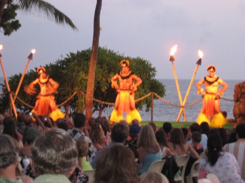 1991 Ford Bronco - Hula dancers perform by the ocean at sunset, with torches lit and an audience in attendance.