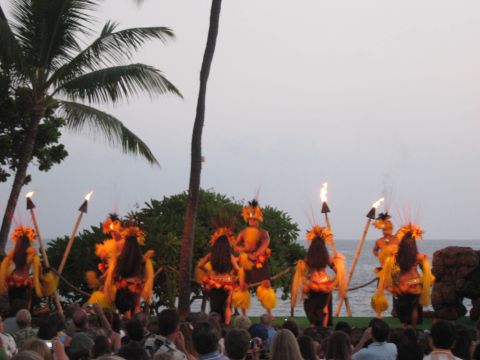 1991 Ford Bronco - A group of hula dancers perform with torches in front of an audience by the ocean.