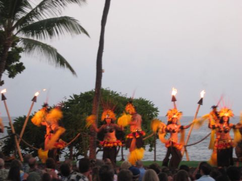 1991 Ford Bronco - A group of performers in traditional attire dance with torches during an outdoor evening show.