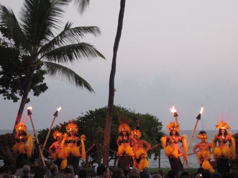 1991 Ford Bronco - Hula dancers perform with torches on a beach, with palm trees and the ocean in the background.