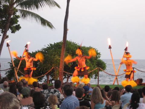 1991 Ford Bronco - Performers in traditional attire dance with fire torches on a Hawaiian beach, entertaining an audience by the ocean.
