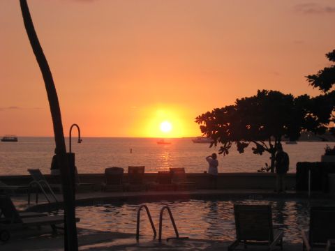 1991 Ford Bronco - A tranquil sunset scene unfolds over the ocean, with a swimming pool and lounge chairs in the foreground.