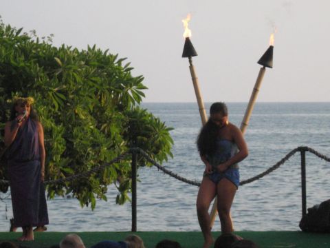1991 Ford Bronco - A luau performance with two women and tiki torches on a stage by the ocean.