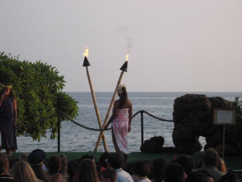 1991 Ford Bronco - A performance takes place on a stage by the ocean with tiki torches, as an audience watches.