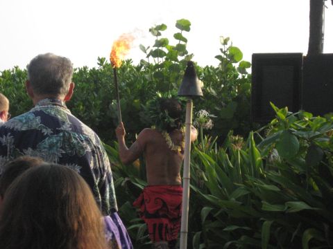 1991 Ford Bronco - A performer holds a flaming torch during an outdoor event, with spectators in the foreground and dense foliage in the background.
