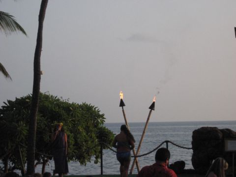 1991 Ford Bronco - A luau performance takes place outdoors with tiki torches lit against a backdrop of the ocean.