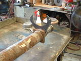 1979 Ford Bronco - A vehicle axle part is shown with a specialized wrench tool, likely in a workshop setting.