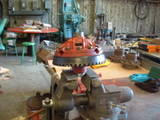 1979 Ford Bronco - Differential gear assembly held in a vise, ready for work in a cluttered garage.
