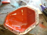 1979 Ford Bronco - A freshly painted oil pan sits on a workbench, ready for installation.