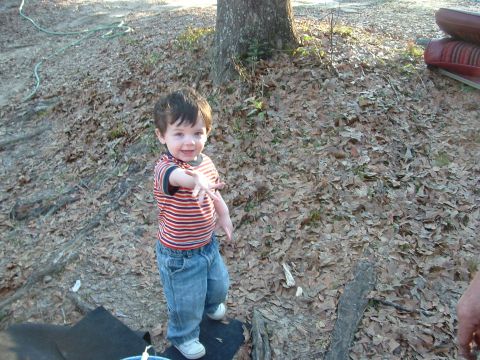 1979 Ford Bronco - A young child in a striped shirt and jeans stands outdoors among fallen leaves, extending an arm towards the camera.
