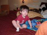 1979 Ford Bronco - A young child is sitting on a bed, looking towards the camera with a smile.