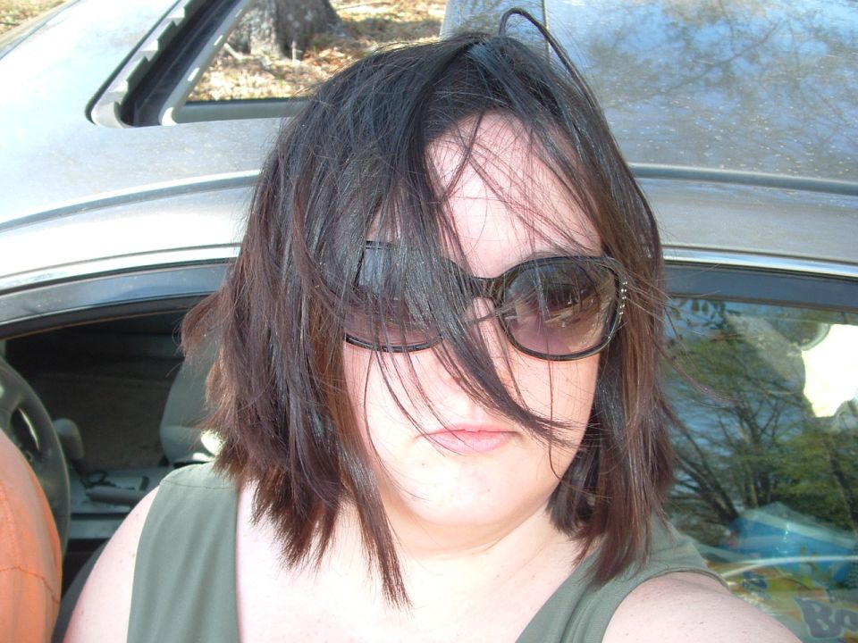 Woman in sunglasses inside a vehicle, with a SuperMotors logo visible