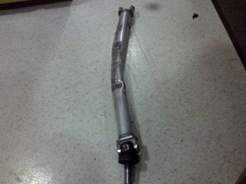 2002 Chevrolet Camaro - This bent driveshaft appears to be damaged and is shown on a speckled surface.