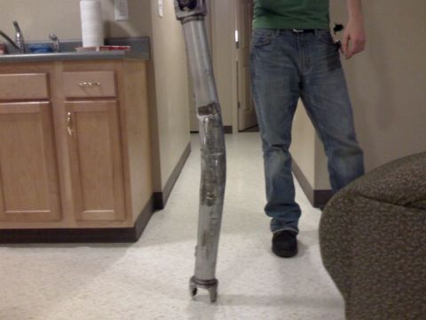 2002 Chevrolet Camaro - A bent driveshaft is shown in a hallway, with a person standing to the right.
