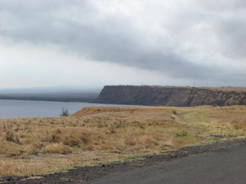 1991 Ford Bronco - A wide view of a coastline under a cloudy sky, with wind turbines visible in the distance.