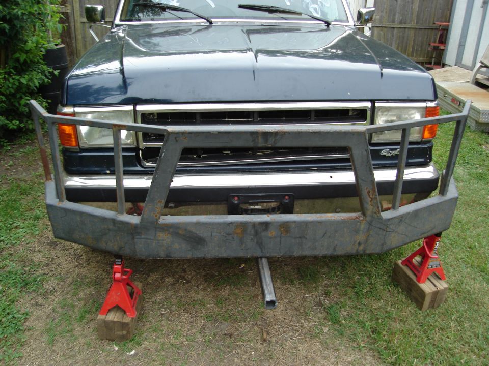 Front of dark blue Ford truck on jack stands with tube bumper and brush guard