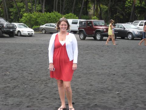 1991 Ford Bronco - A woman stands on a black sand beach with multiple vehicles parked in the background.