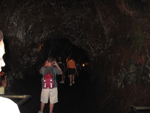 1991 Ford Bronco - Tourists explore a natural lava tube cave, illuminated by artificial lights.