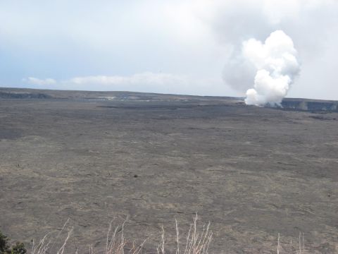 1991 Ford Bronco - Expansive view of a volcanic area with steam erupting from a crater in the distance.