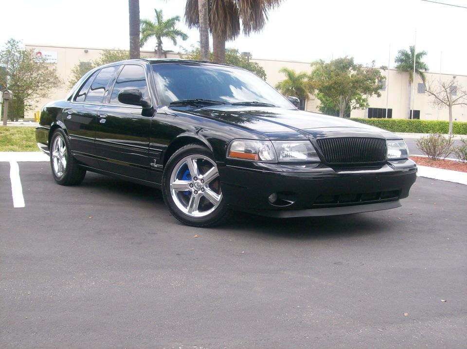 Black Mercury Marauder sedan, 3/4 front view, chrome wheels and blue calipers, in parking lot
