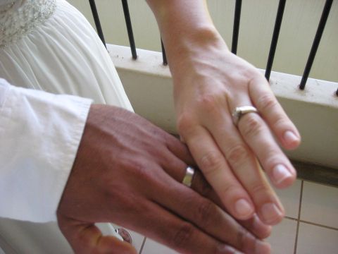 1991 Ford Bronco - A close-up shows two hands, one with darker skin and one with lighter skin, both adorned with wedding rings.
