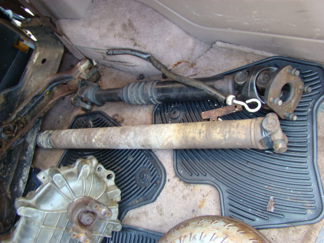 Two driveshafts and a differential housing inside a vehicle.